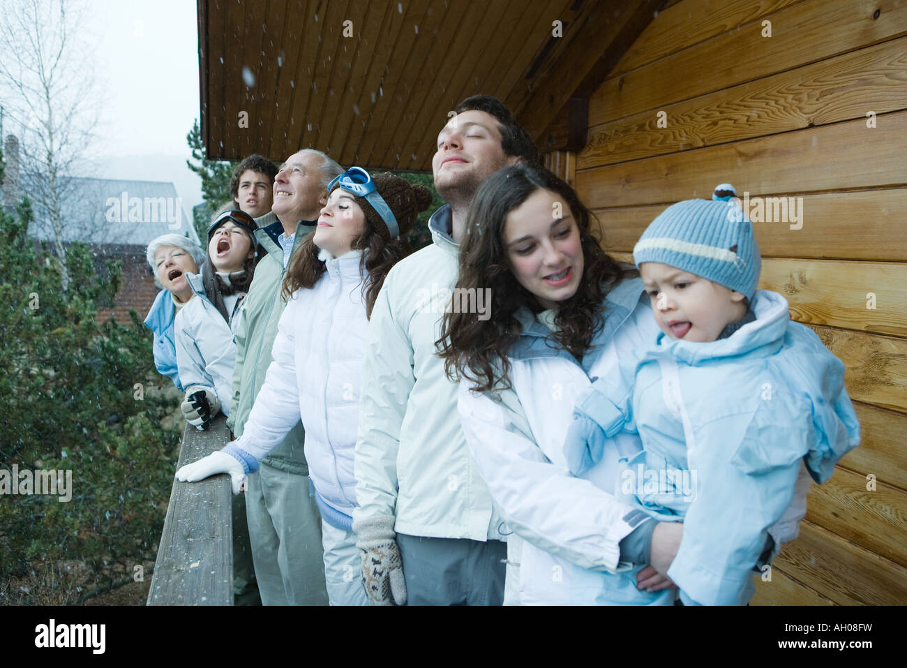 Gemischtes Alter stehend im Schnee, auf dem Deck der Holzhütte Stockfoto