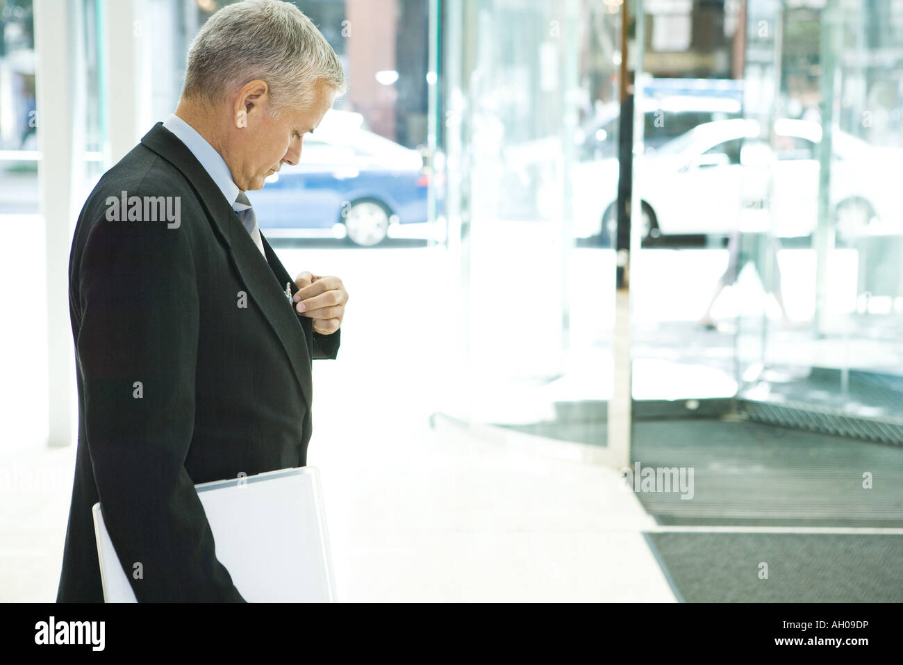 Unternehmer auf der Suche nach unten, Seitenansicht Griff nach Stift in der Tasche, Stockfoto