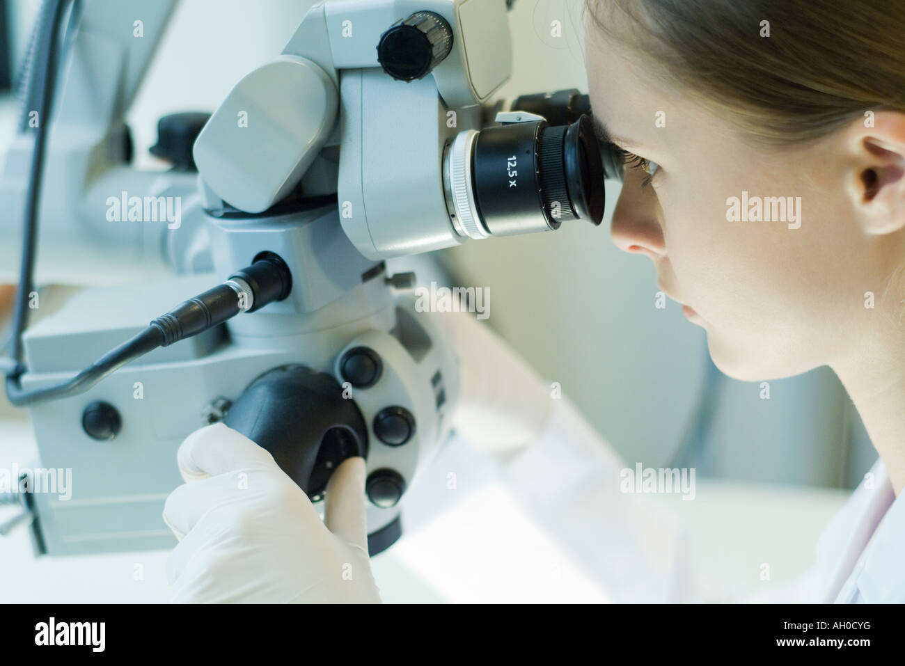 Junge Frau im wissenschaftlichen Labor arbeiten mit Mikroskop Stockfoto