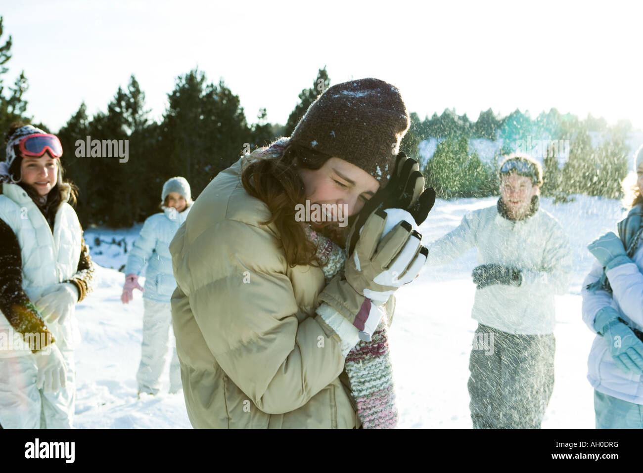 Junge Freunde werfen Schneebälle, lächelnd, verschwommen Bewegung Stockfoto
