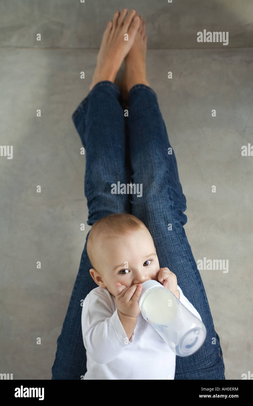 Babysitter auf Frau Schoß, trinken aus Baby-Flasche Stockfoto