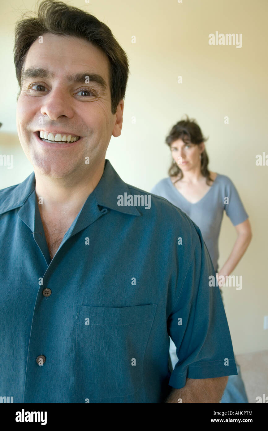 Mann lächelnd mit Frau im Hintergrund Stockfoto