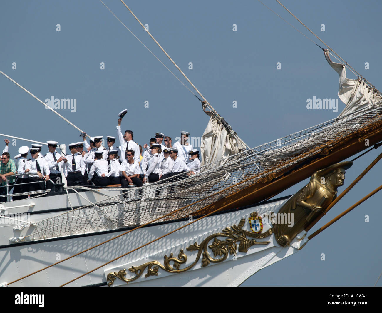 Weiß uniformierten Matrosen auf dem Bogen der Großsegler Sagres II, einer von ihnen winkt seinen Hut Sail Amsterdam 2005 Stockfoto