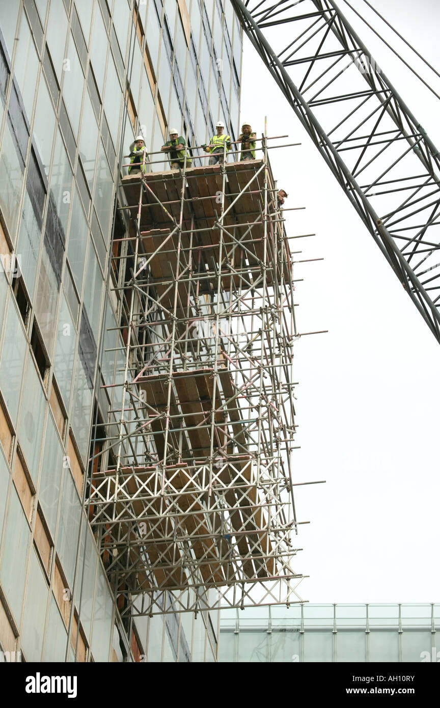 Arbeiter im Baugewerbe eine Pause auf überhängenden Gerüst Plattform im städtischen Bereich Stockfoto