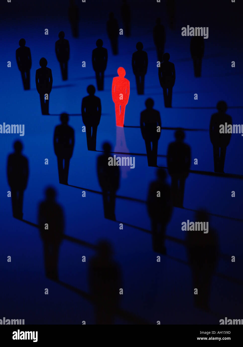 Einsame rote Person in einem Feld von blauen Menschen Stockfoto