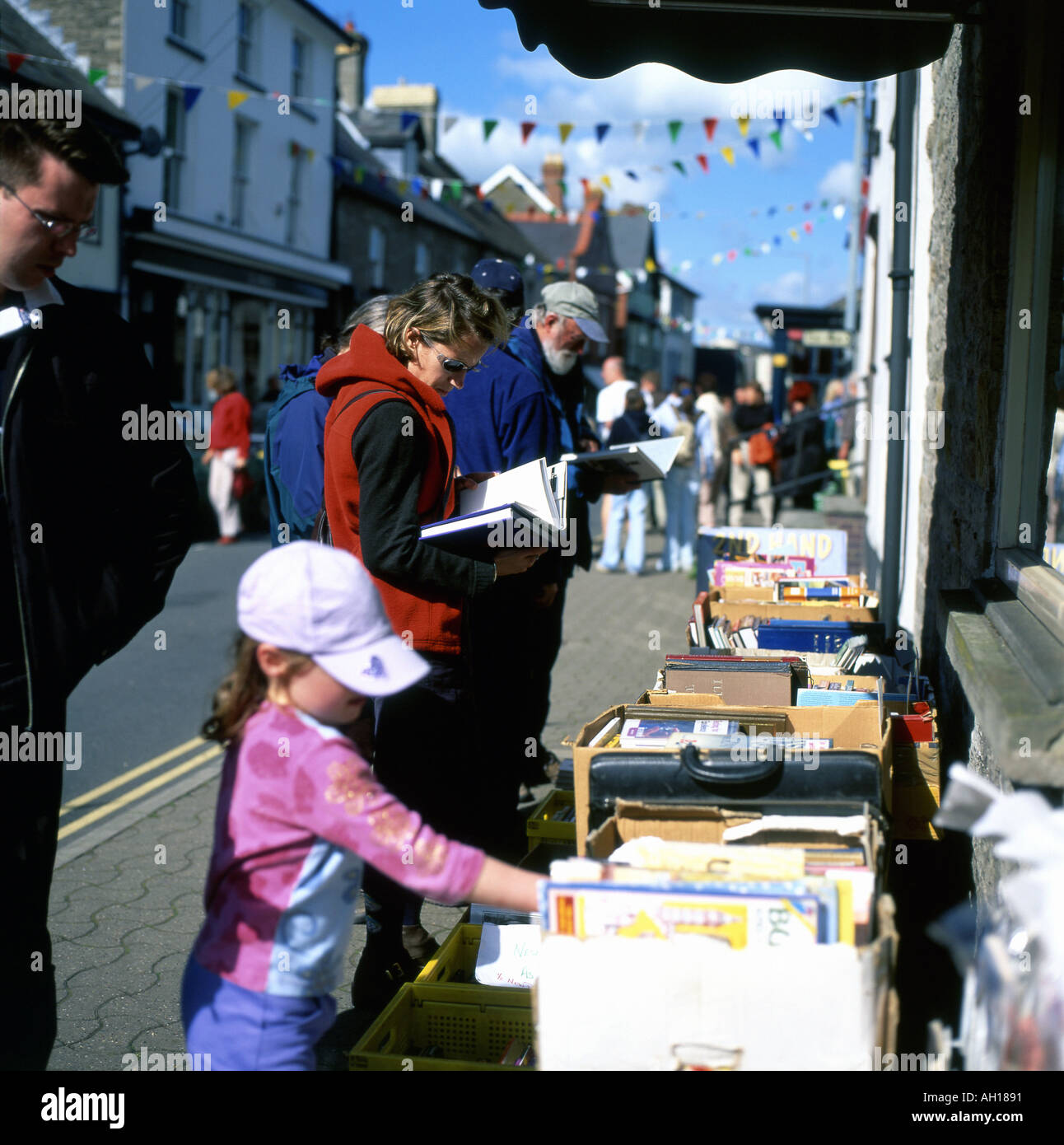 Familie und Kind einkaufen Bücher auf einem Bücherstand außerhalb Hay-on-Wye Buchhandlung anschauen, während das Hay-Festival, Wales, UK KATHY DEWITT Stockfoto