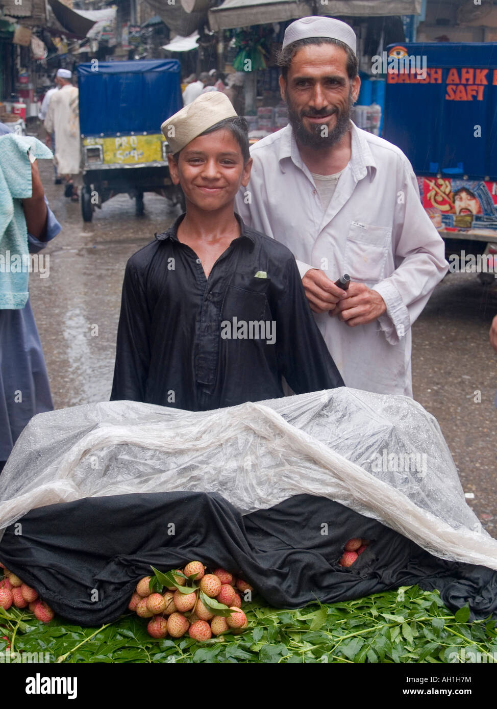 Vater und Sohn Litschi-Verkäufer in Peshawar, Pakistan Stockfoto