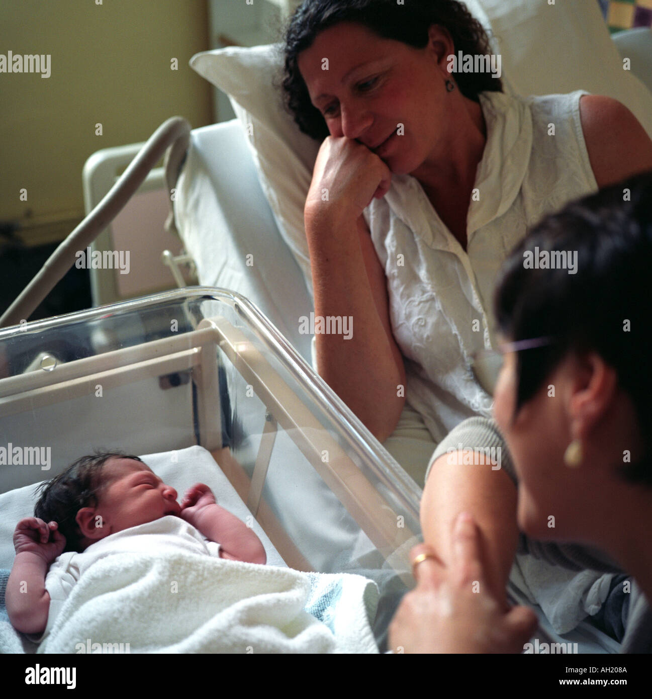 L-r: Babymädchen Stunden früher, Mutter und Freund, Maternity Ward, University College London Hospital, London, UK geboren. 2003. Stockfoto