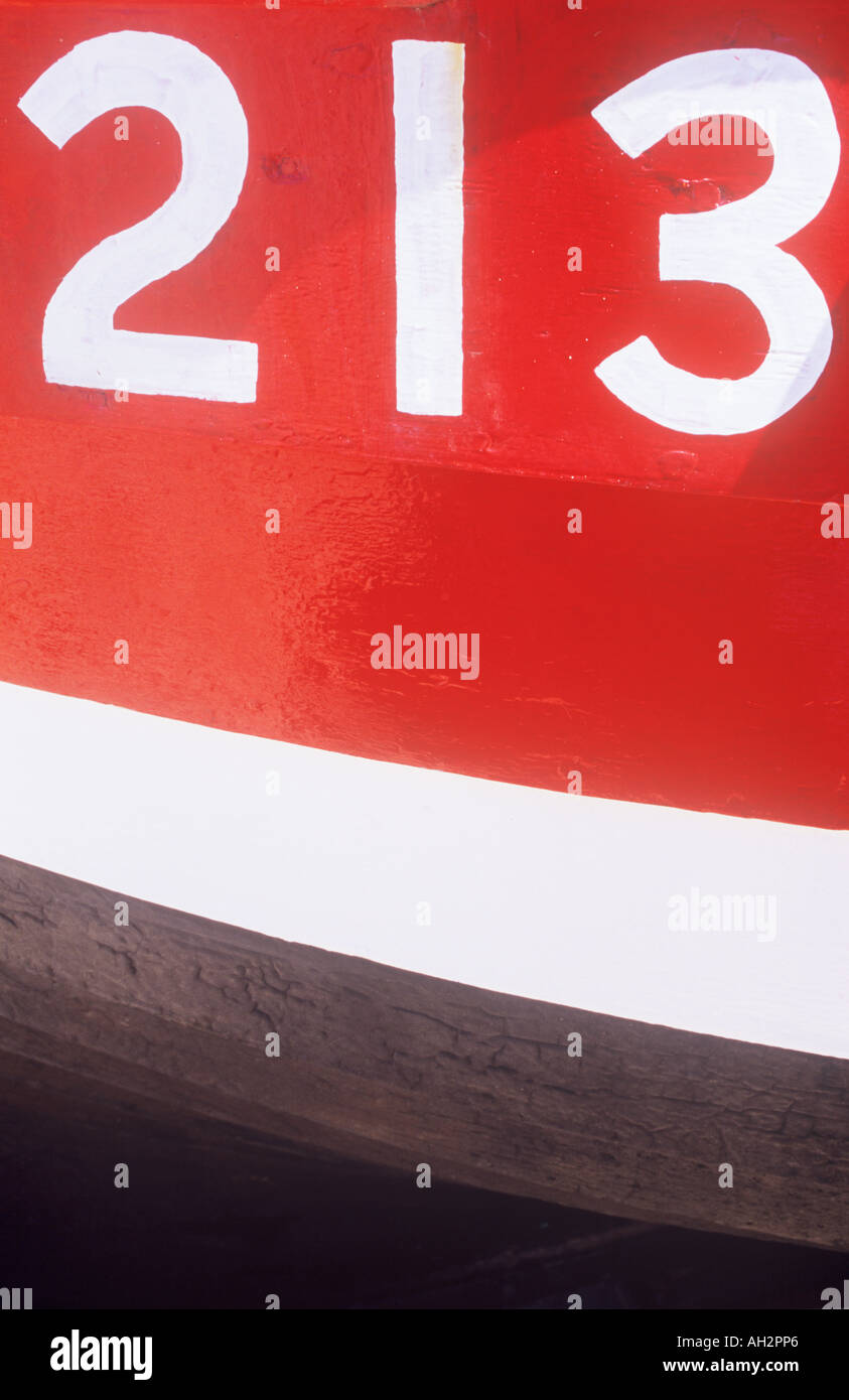 Nahaufnahme eines weißen Zahlen 213 auf die rote Fläche eines Bootes mit weißen und schwarzen Streifen unten gemalt Stockfoto