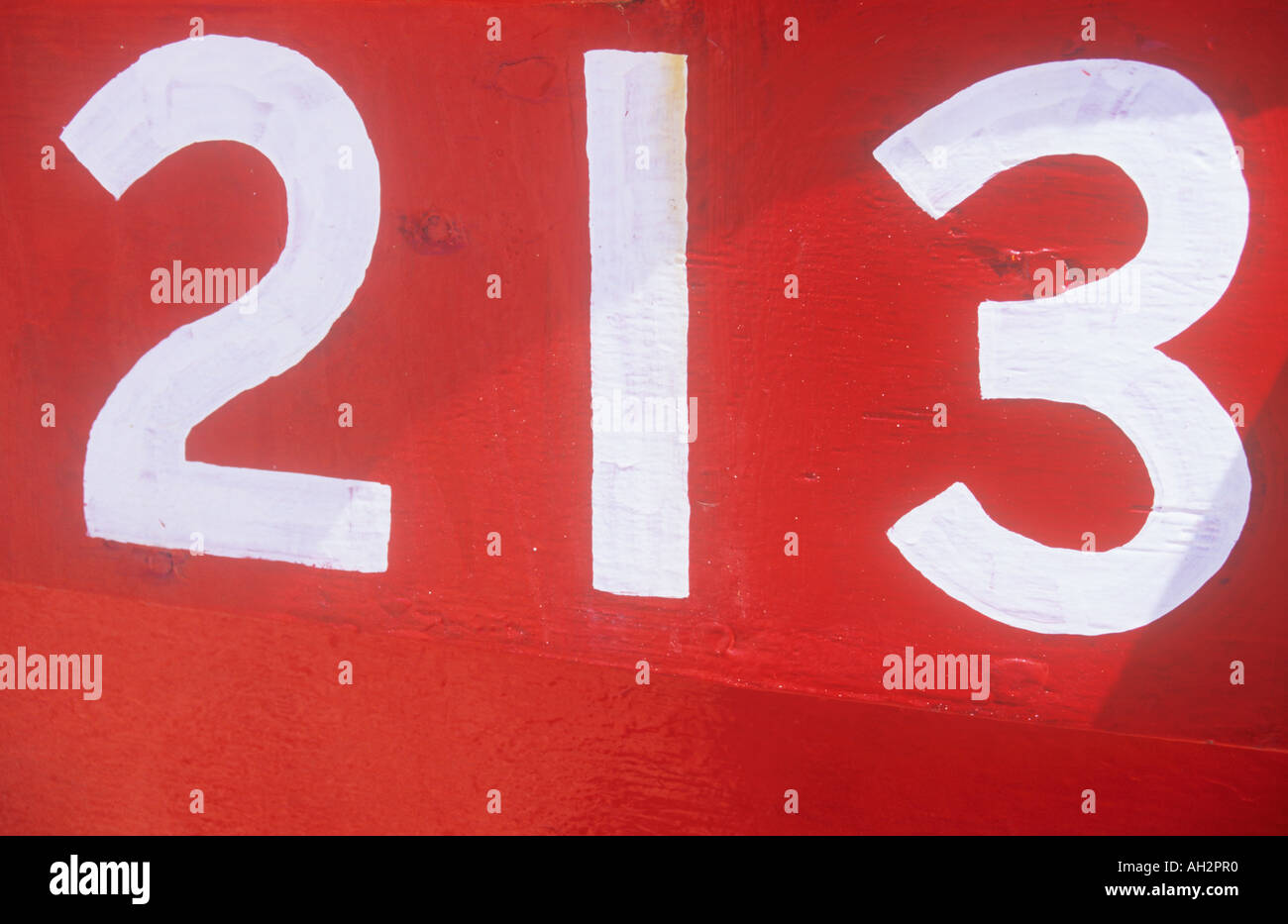 Nahaufnahme eines weißen Zahlen 213 auf die rote Fläche eines Bootes gemalt Stockfoto