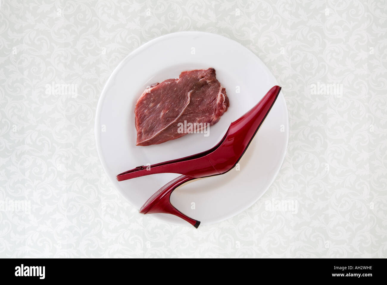 rote high-Heel mit Fleisch auf weißen Teller, Studio gedreht Stockfoto