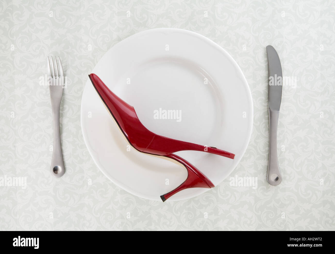 rote high-Heel mit Utensilien auf weißen Teller, Studio gedreht Stockfoto