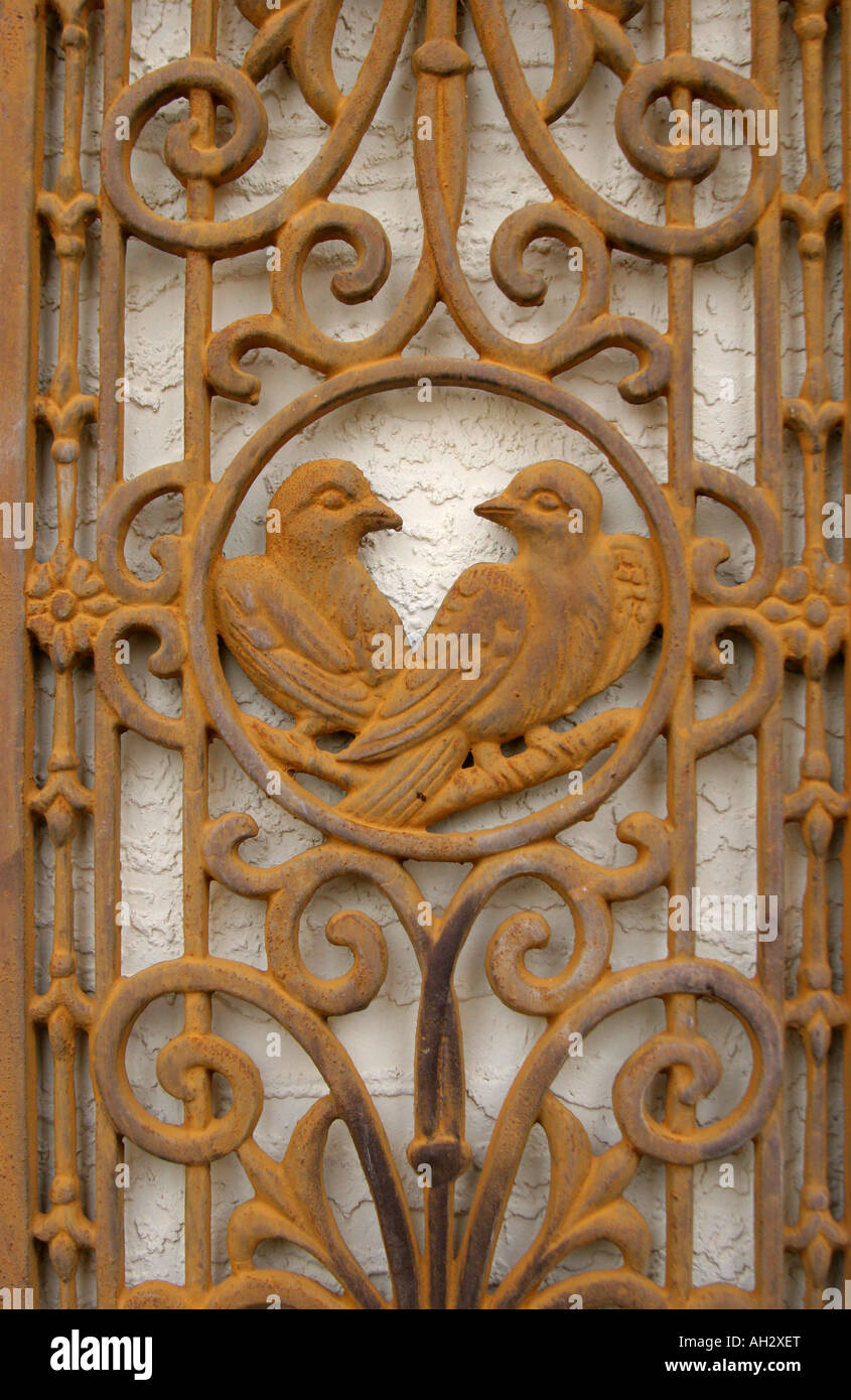 Dekorative Tauben in einem schmiedeeisernen ornamentalen Eisentür Stockfoto