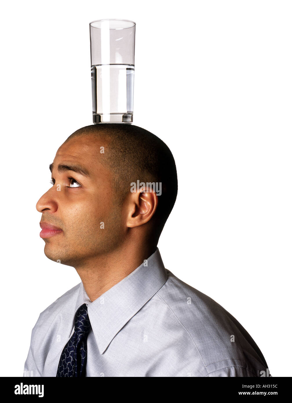 African American Mann mit Glas Wasser auf Kopf Stockfoto