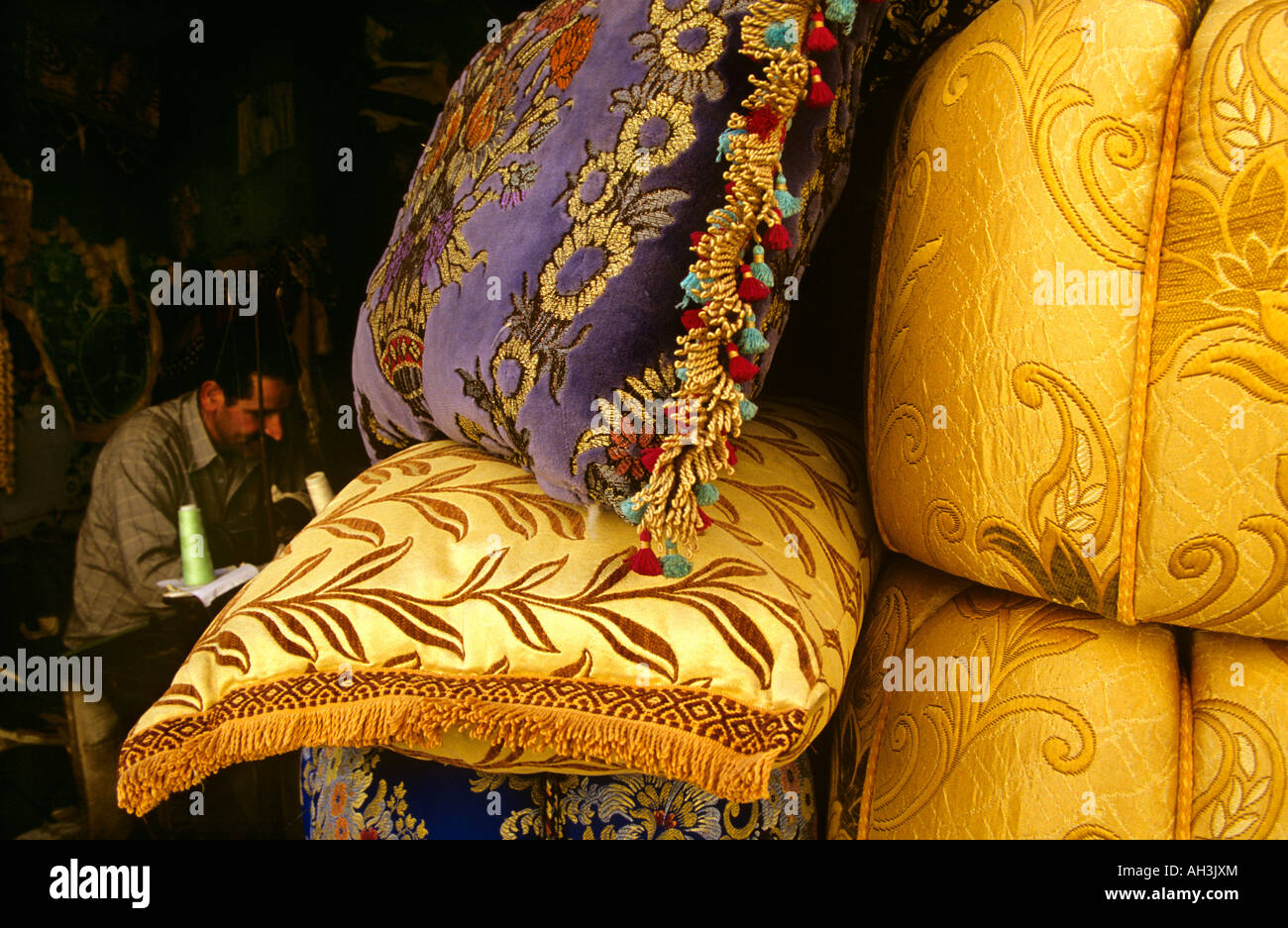 Bestickte Kissen und Polster bei der Arbeit in Chefchaouen medina, Marokko, die traditionelle Textilhandwerkskunst hervorheben. Stockfoto