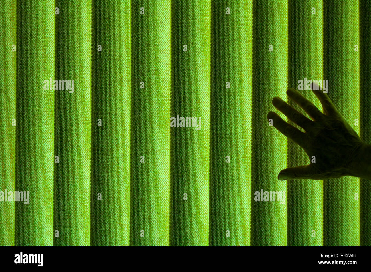 Silhouette der geheimnisvolle Hand gegen grünen Jalousien Stockfoto