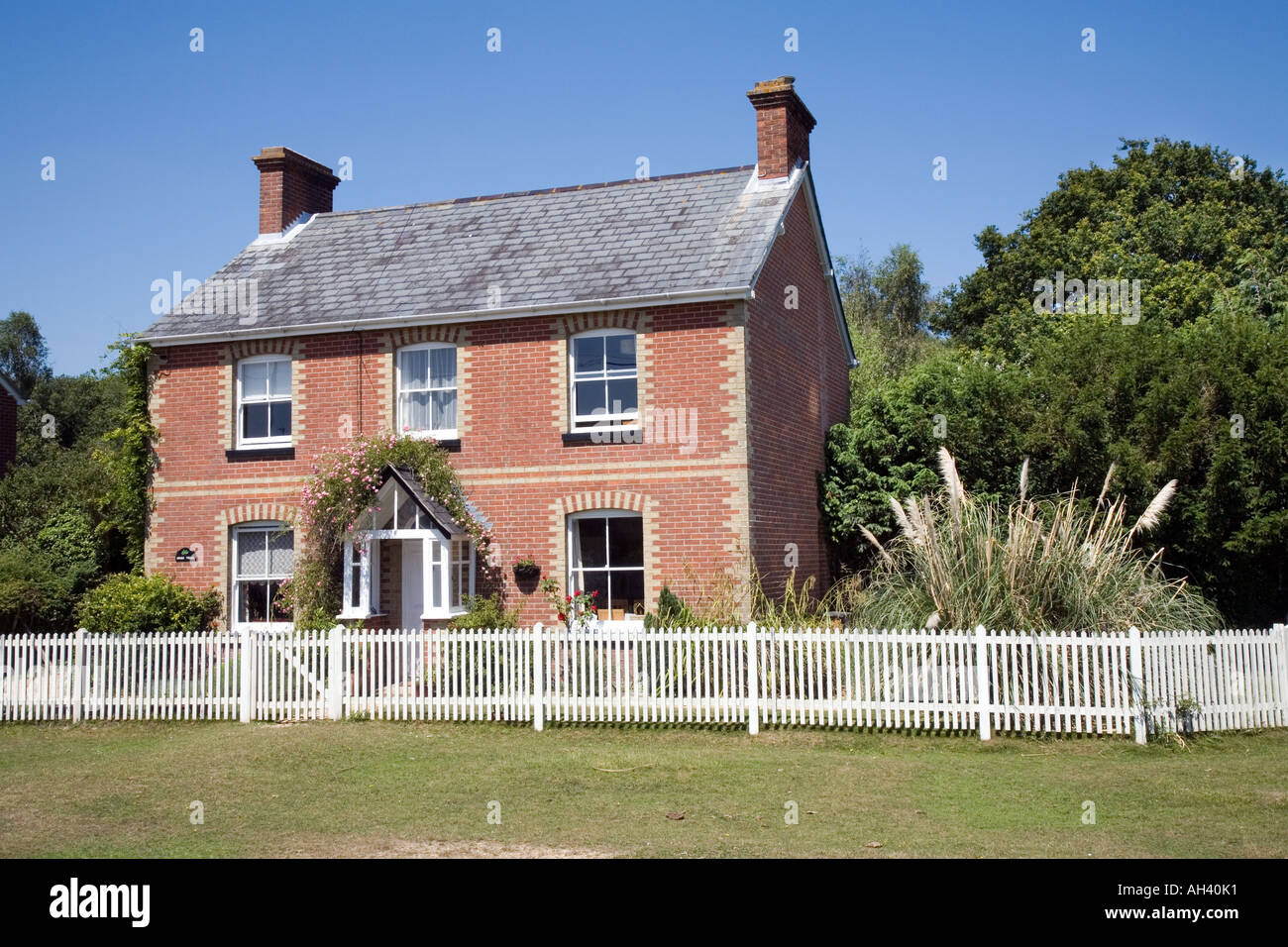 Aus rotem Backstein Ferienhaus mit weißen Pickett Zaun im Wald von New Hampshire Stockfoto