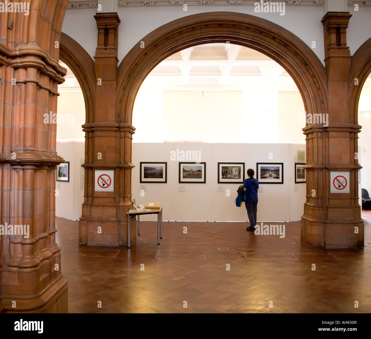 Frau betrachten Fotografien in einer Ausstellung in der Pierhead Gebäude Cardiff Wales UK Stockfoto