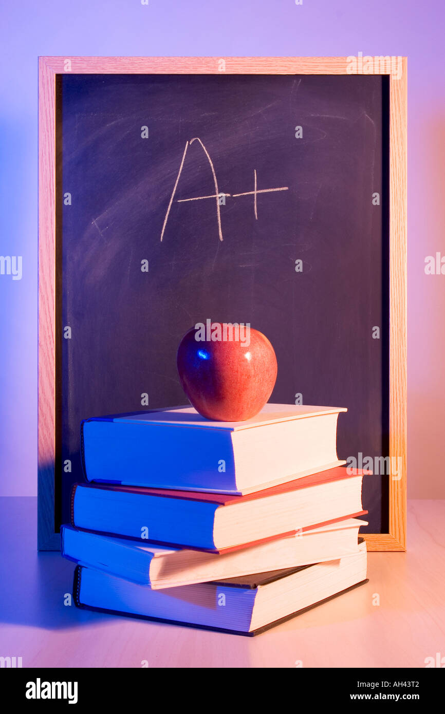 Apfel auf Bücher vor einer Tafel mit einem Plus darauf geschrieben. Stockfoto