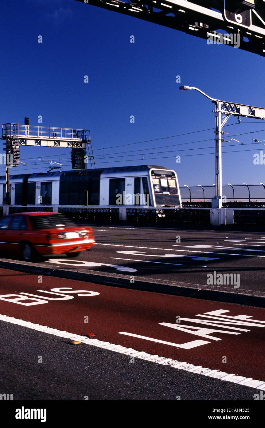 Busspur gemalt tiefrot auf Sydney Harbour Bridge mit PKW und Bahn über die Brücke im Hintergrund Stockfoto