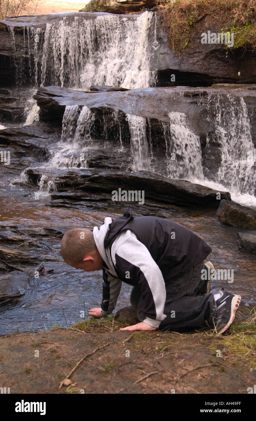 Kaukasische junge jungen 10-12 Jahre spielt im Wasser am Lake Lure Wasserfall in Chimney Rock, North Carolina USA Stockfoto