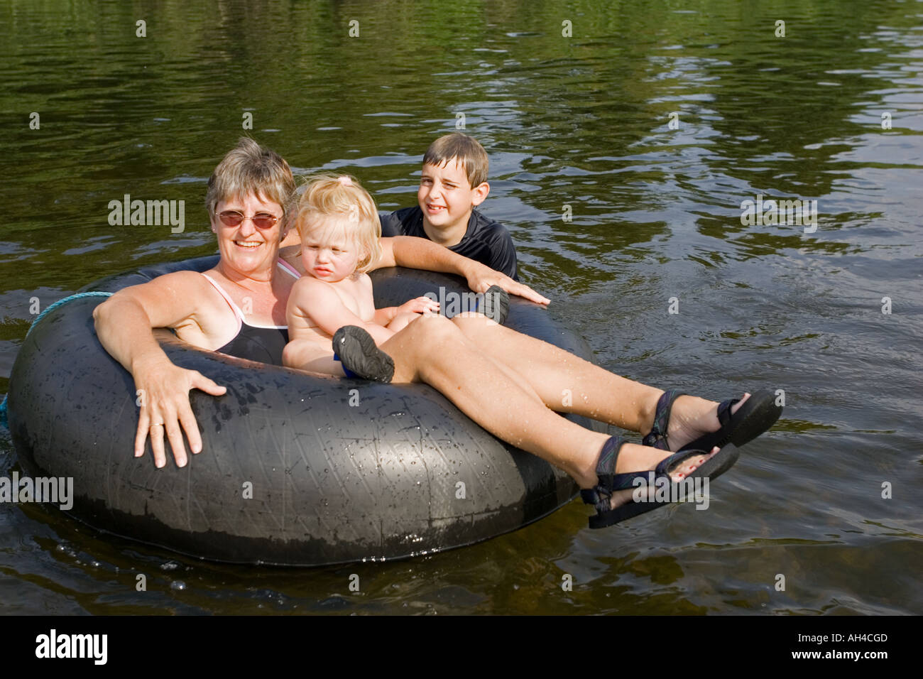 Mutter und Kinder halten im großen inneren Gummischlauch im Fluss Wye kühl an heißen Tag UK Stockfoto