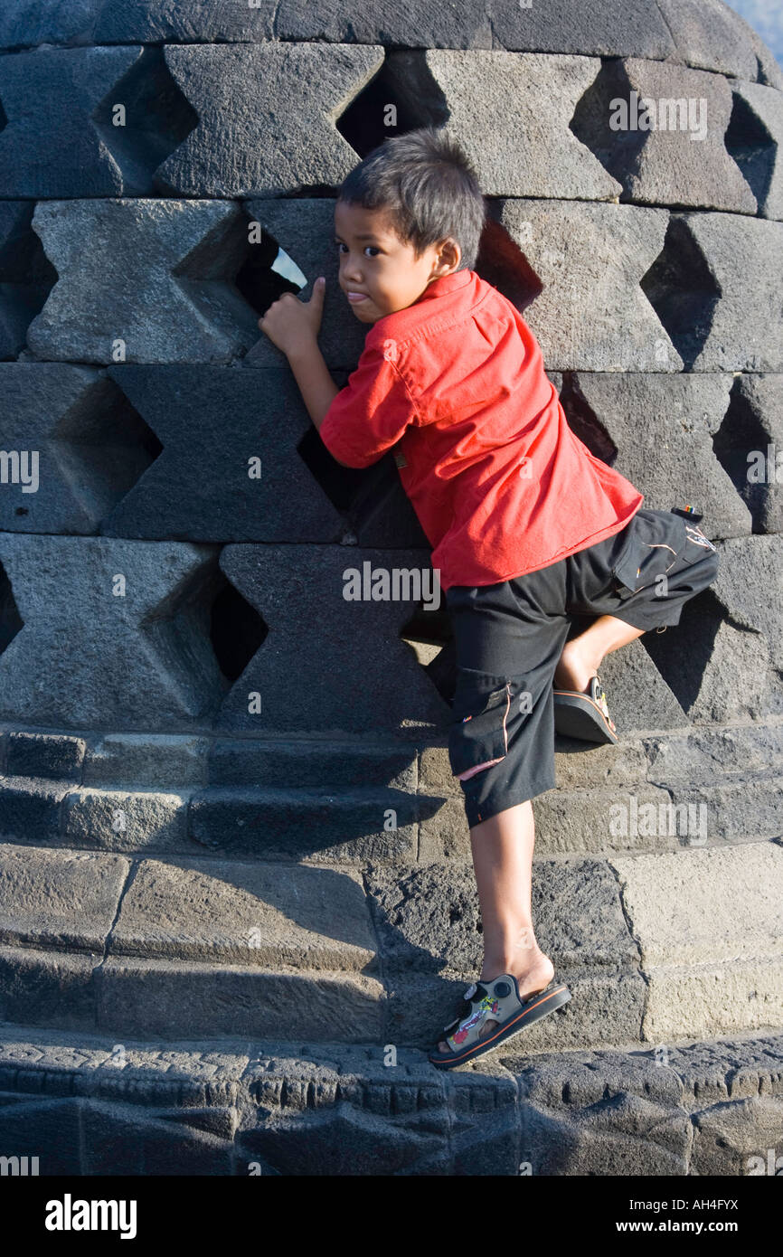 Indonesische junge erreicht, die Hände des Buddha für Glück Borobudur Indonesien zu berühren Stockfoto