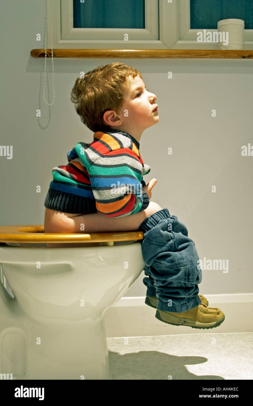 Kleiner junge Kind sitzt auf der Toilette WC Toilette oder Moor von der  Seite mit Multi farbige Jersey oder Jumper NAOH Stockfotografie - Alamy