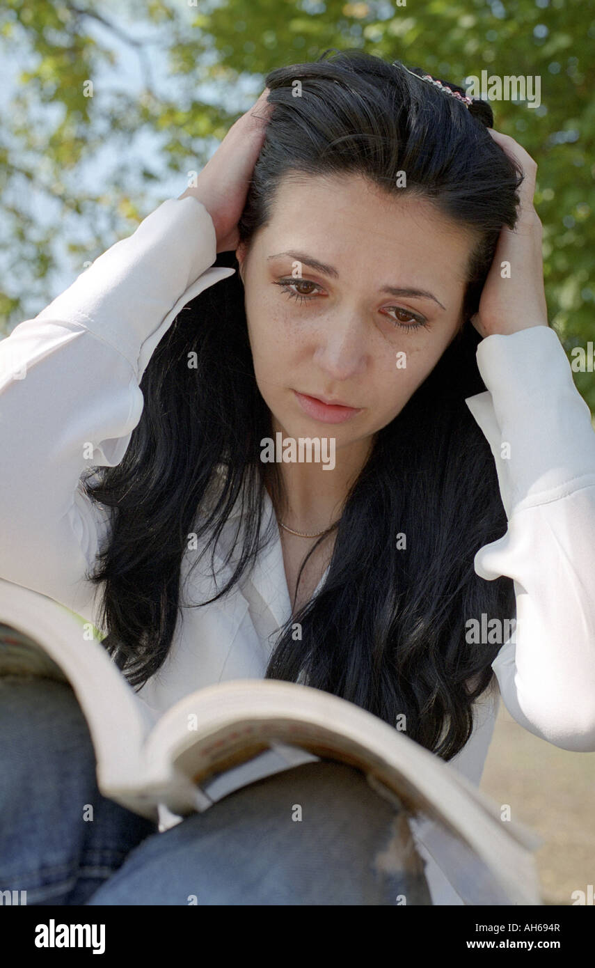 Frau-Lesebuch vor Prüfung Stockfoto