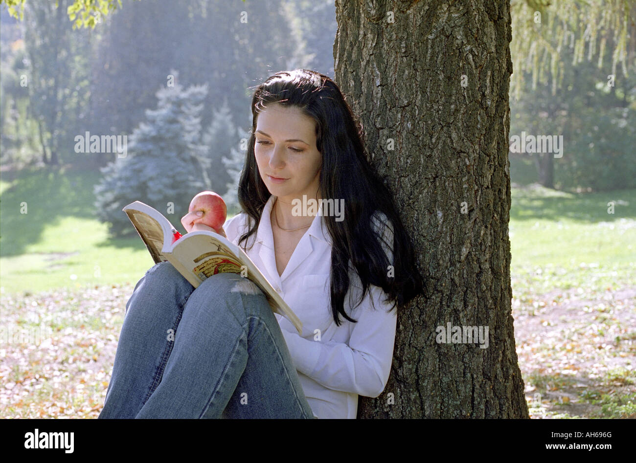 Lesende Frau mit Apfel Stockfoto