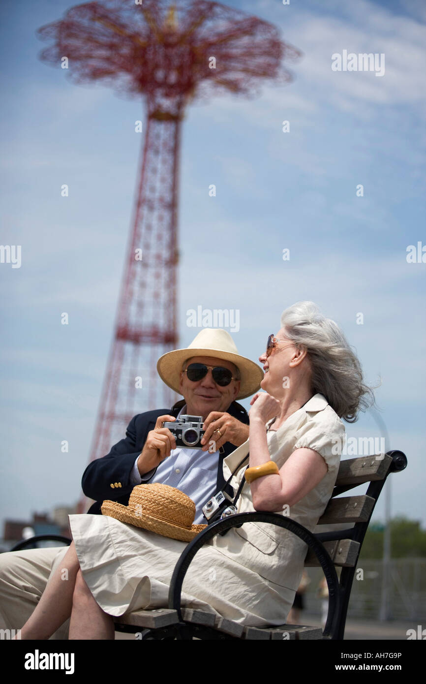 Älteres paar sitzen auf einer Bank, Parachute Drop, Coney Island, New York City, New York, USA Stockfoto