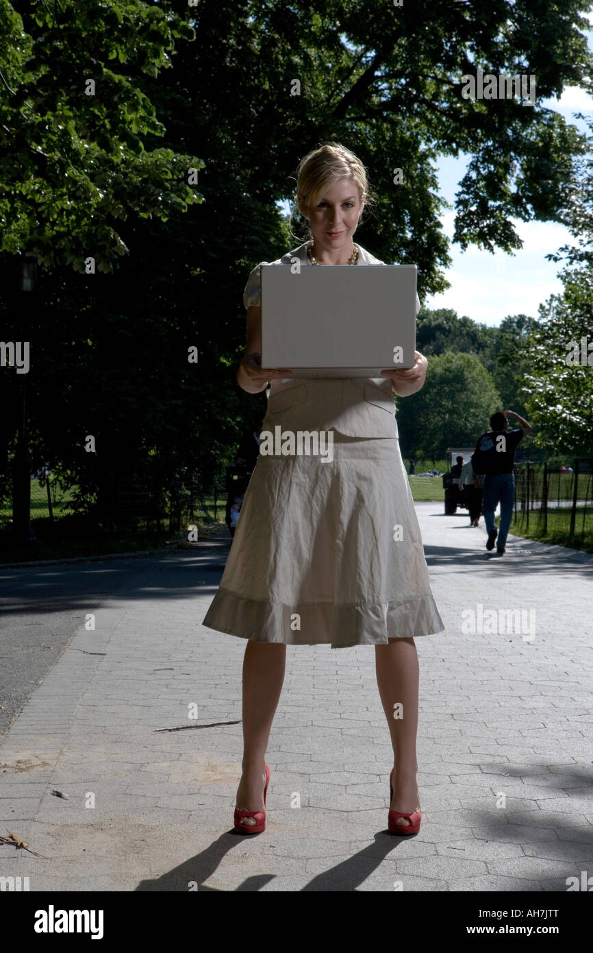 Junge Frau mit einem Laptop und stehend auf einem Pfad Stockfoto