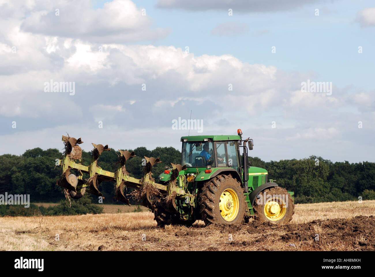 John Deere Traktor drehen während des Pflügens Stoppeln Field, Warwickshire, England, UK Stockfoto