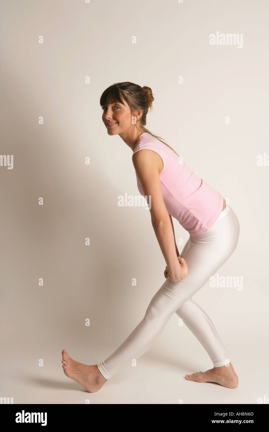 Junge Frau, die Dehnung im Rahmen einer Routine-Übung Fitness Gesundheit und Wohlbefinden Stockfoto
