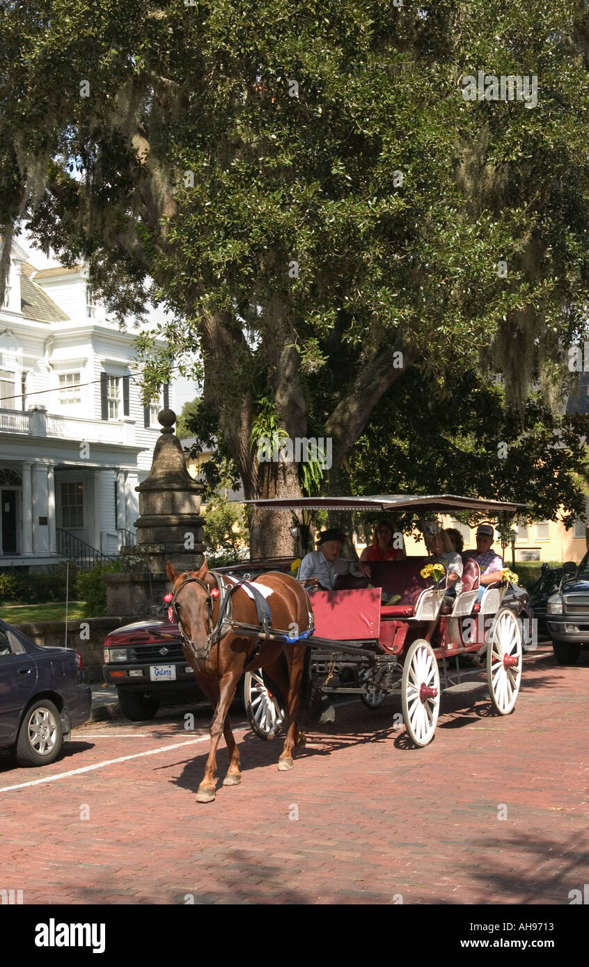 Schöne rote Pferdekutsche mit Fahrer und Touristen, die das historische St. Augustine, Florida, USA, besichtigen. Stockfoto