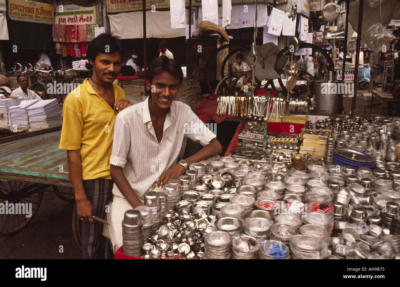 Zwei junge inder, die auf dem Markt der Altstadt von Ahmedabad, Gujarat, Indien, Utensilien aus Stahl verkaufen. Stockfoto