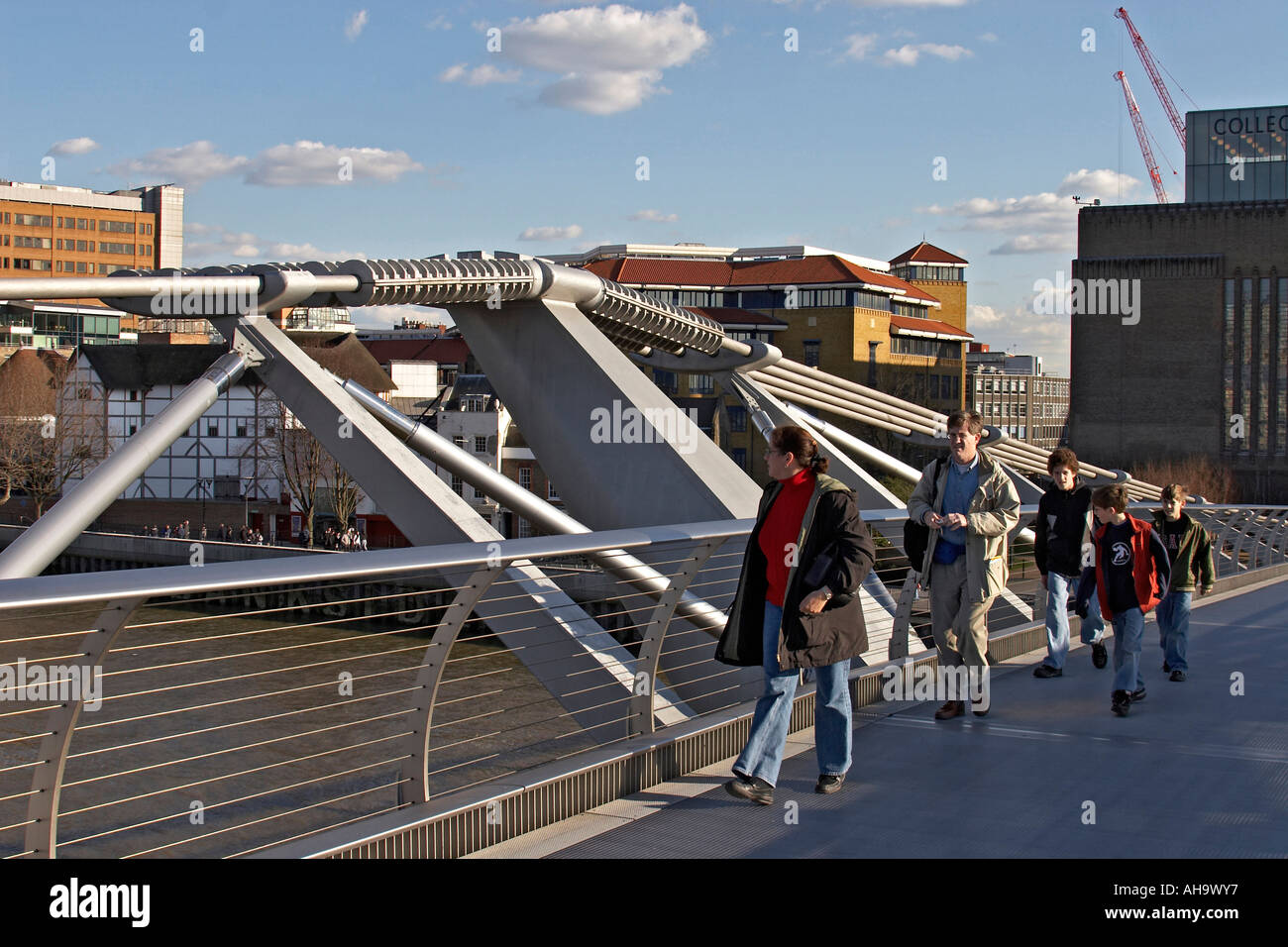 Menschen zu Fuß auf Millennium Bridge über die Themse mit Globus Theatergebäude in Stadt von London EG4 England Entfernung Stockfoto