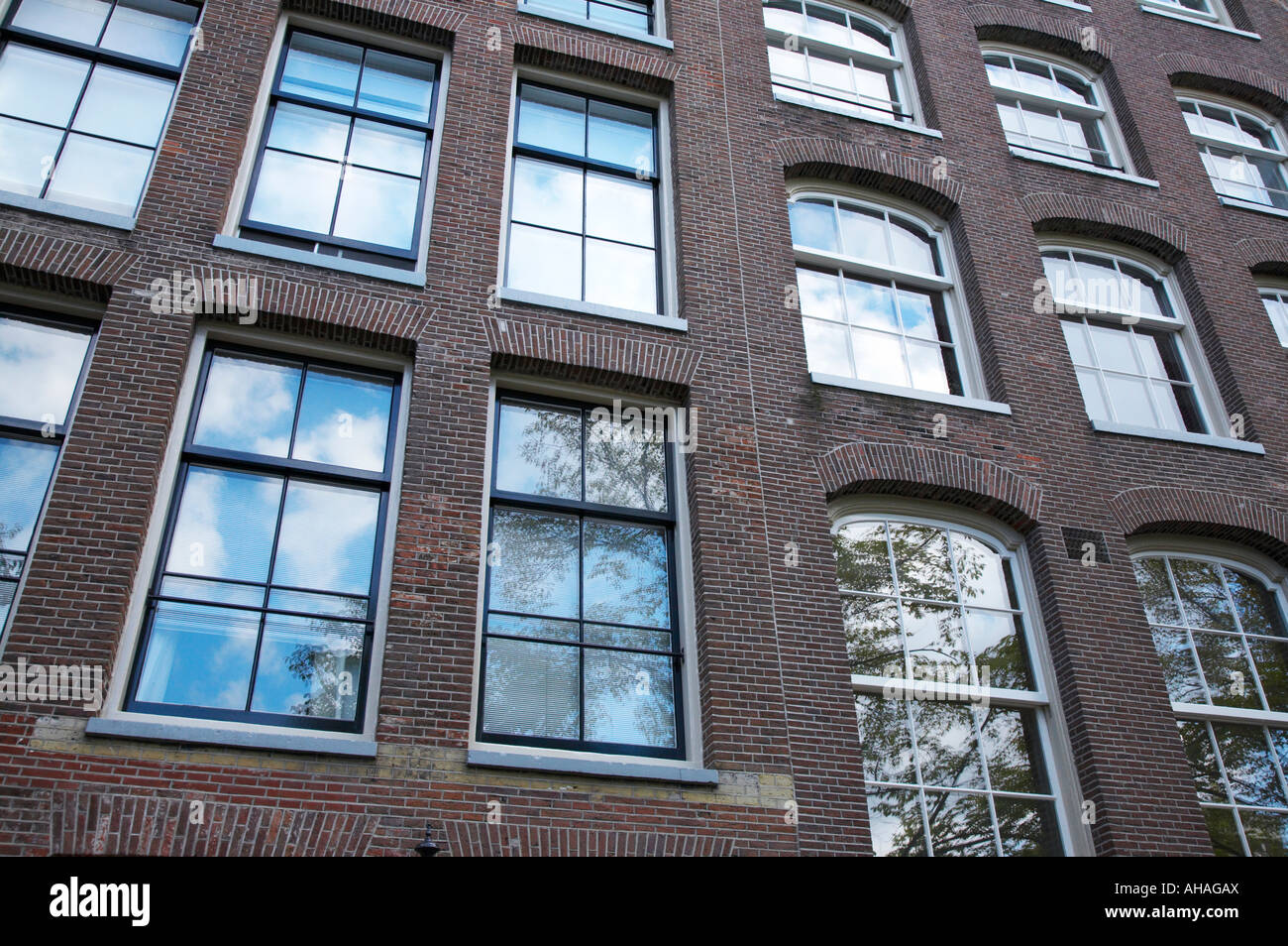 Zusammenfassung von Windows auf Gebäude mit Reflexionen von Himmel und Bäume Amsterdam Stockfoto