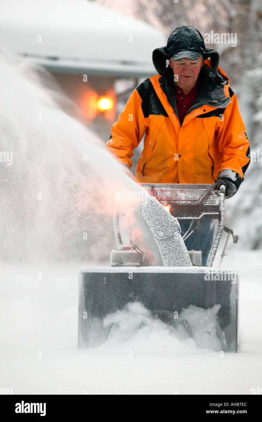 Mann Snowblowing seiner Einfahrt nach frischen Winter Schneesturm Modell Eigentum veröffentlicht Stockfoto
