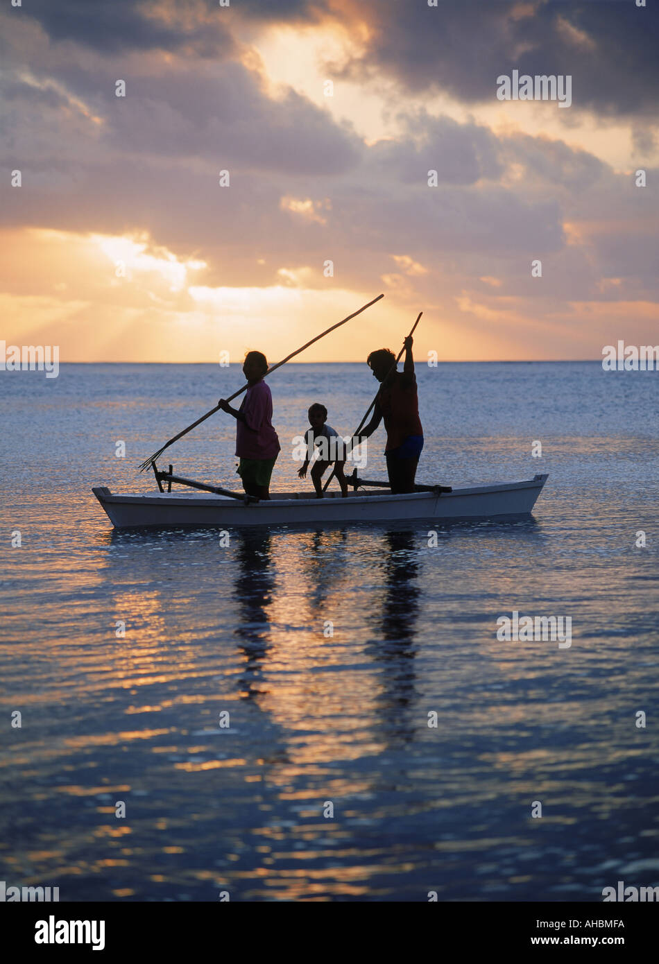 Familie im Auslegerkanu spearfishing auf Insel Aitutaki Lagune auf den Cook Inseln bei Sonnenuntergang Stockfoto