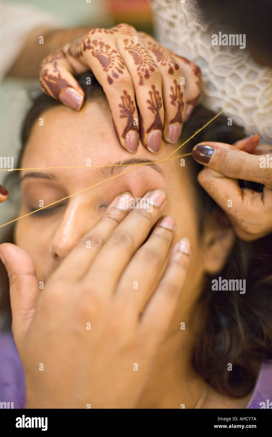 Threading Augenbrauen entfernen Sie Haare in einem Schönheitssalon in Pakistan Stockfoto