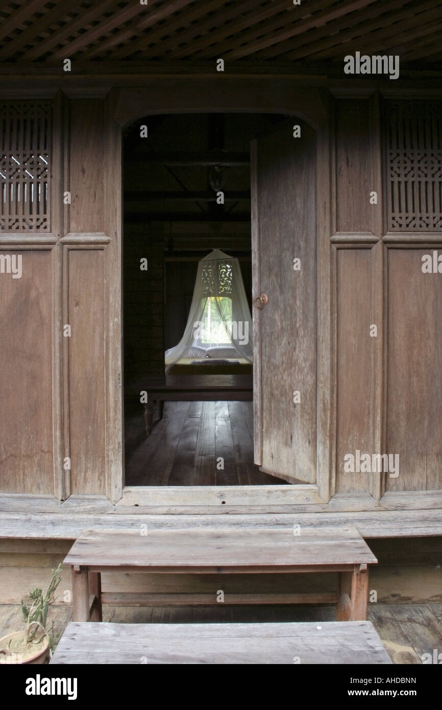 Blick aus einem Schlafzimmer aus halb geschlossenen Tür eines traditionellen malaiischen Haus in Terengganu, Malaysia Stockfoto