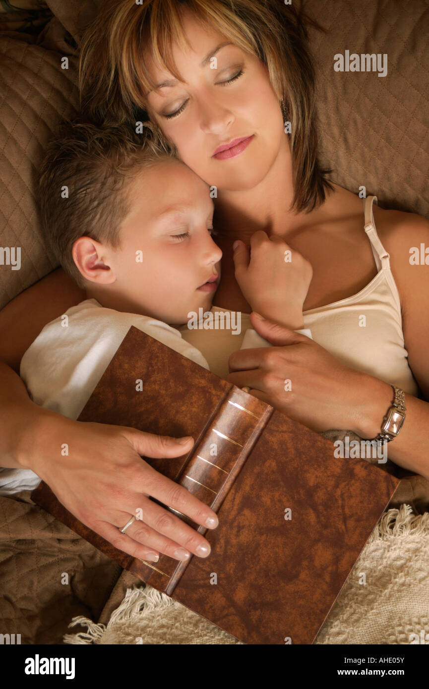 Mutter und Sohn schläft nach der Lektüre auf einem Bett mit Buch über Sie Stockfoto