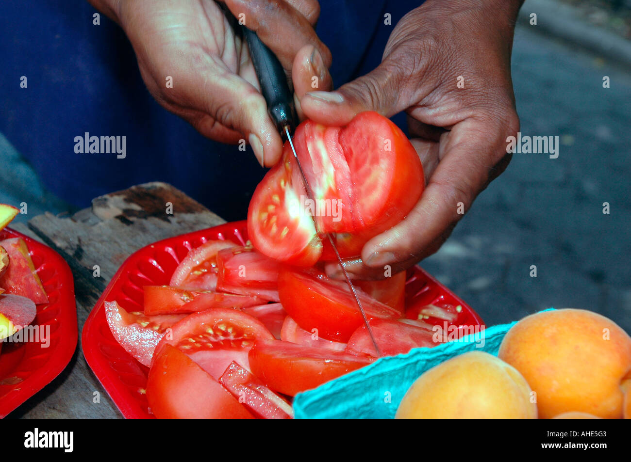 Schneiden von Tomaten Proben, Greenmarket Tompkins Square Park in New York City Stockfoto