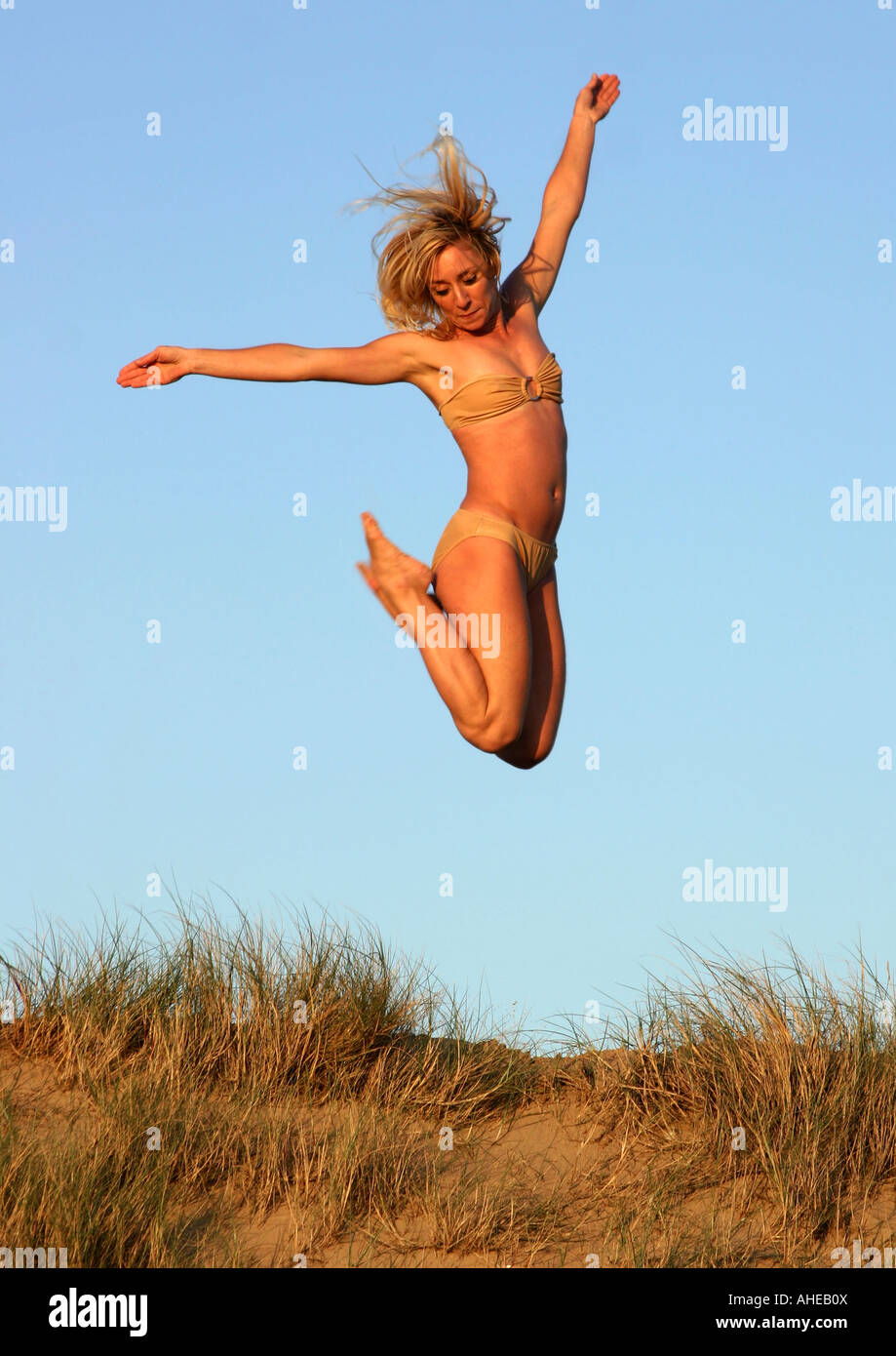 Frau, springen über Sanddünen Stockfoto