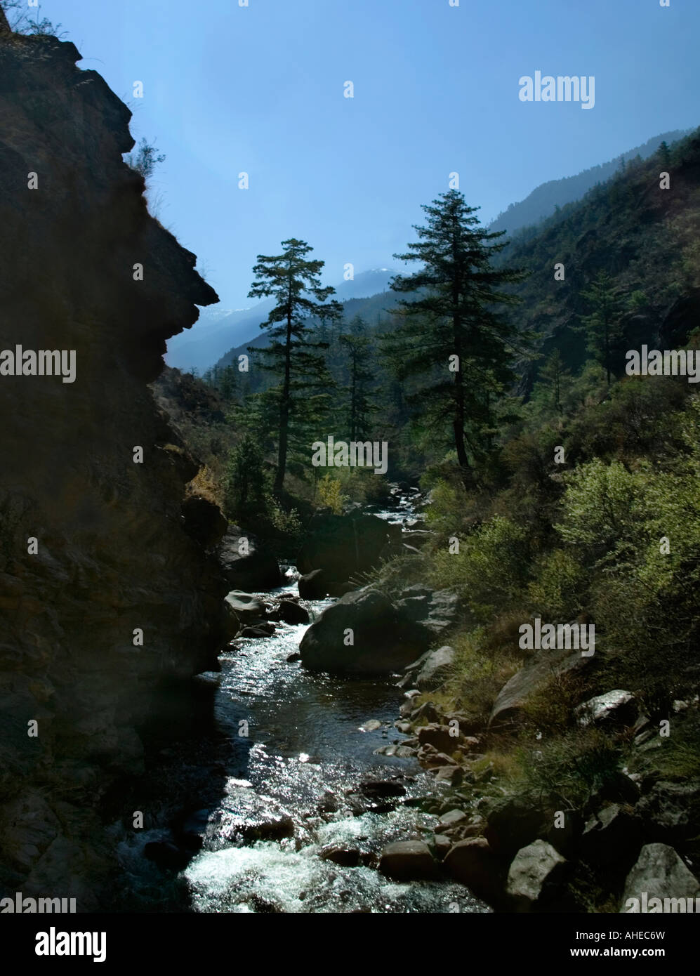 Ein schnell fließender Nebenfluss des Paro Chu mit Schnee bedeckt Himalaya-Gipfel im Hintergrund in der Nähe von Chhuzom Paro Provinz Western Bhutan Stockfoto