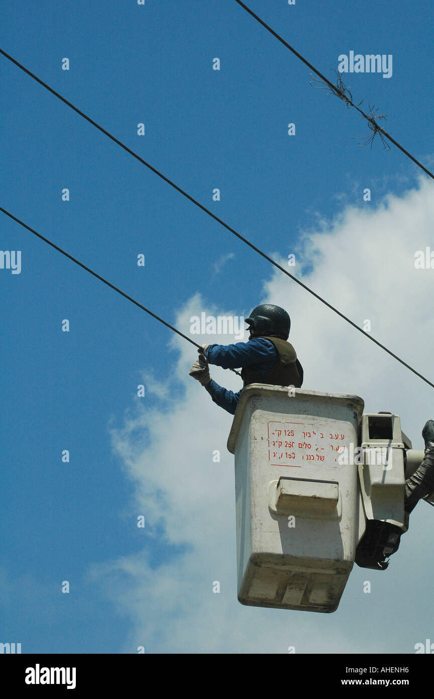 Arbeiter mit Schutzflakjacke und Helm, die Probleme in der Stromleitung in der Nähe der libanesischen israelischen Grenze in Israel beheben Stockfoto