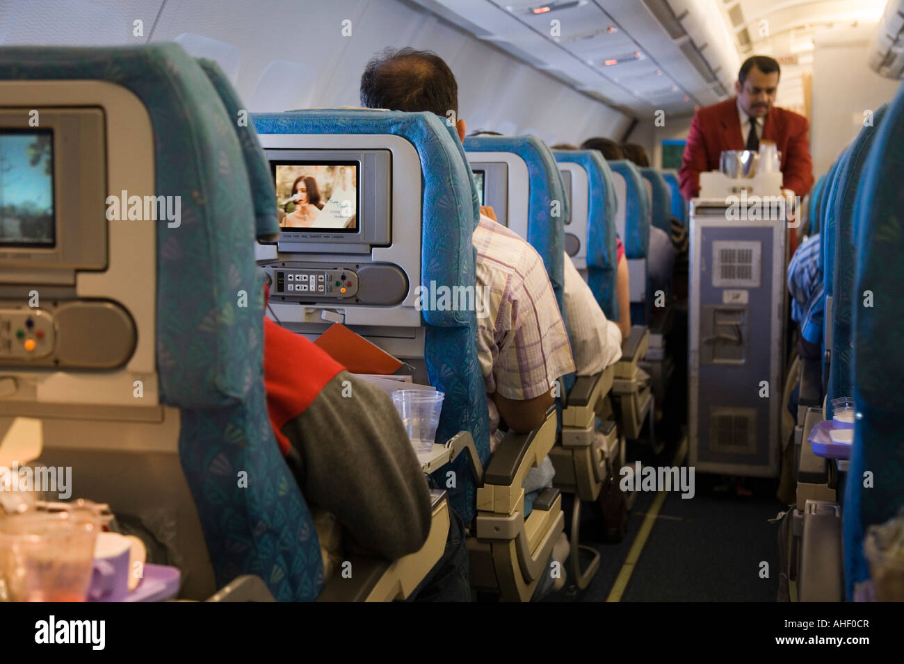 Flugbegleiter/Flugbegleiter im Kabinengang, der Passagiere auf einem SriLankan-Flug von London nach Columbo bedient. Stockfoto