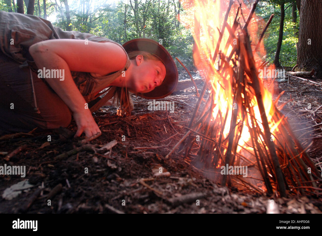 Frau Wildnis Experten veranschaulicht, wie einen Lagerfeuer anzünden. Stockfoto