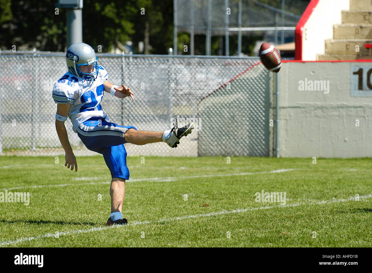 High School Football Player Kicken eines Punt in einem Fußballspiel Stockfoto